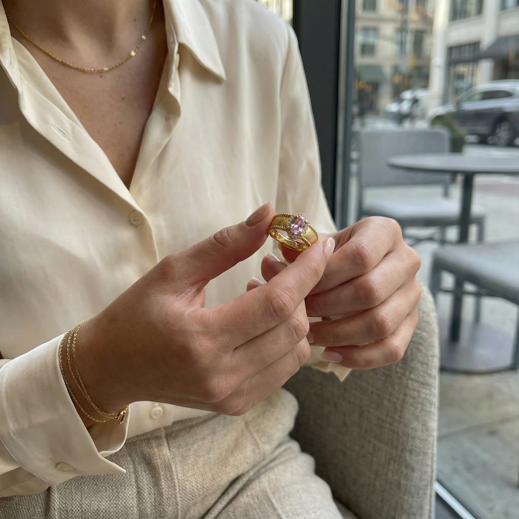 Woman holding a gold vintage pink gemstone ring showing detail and craftsmanship