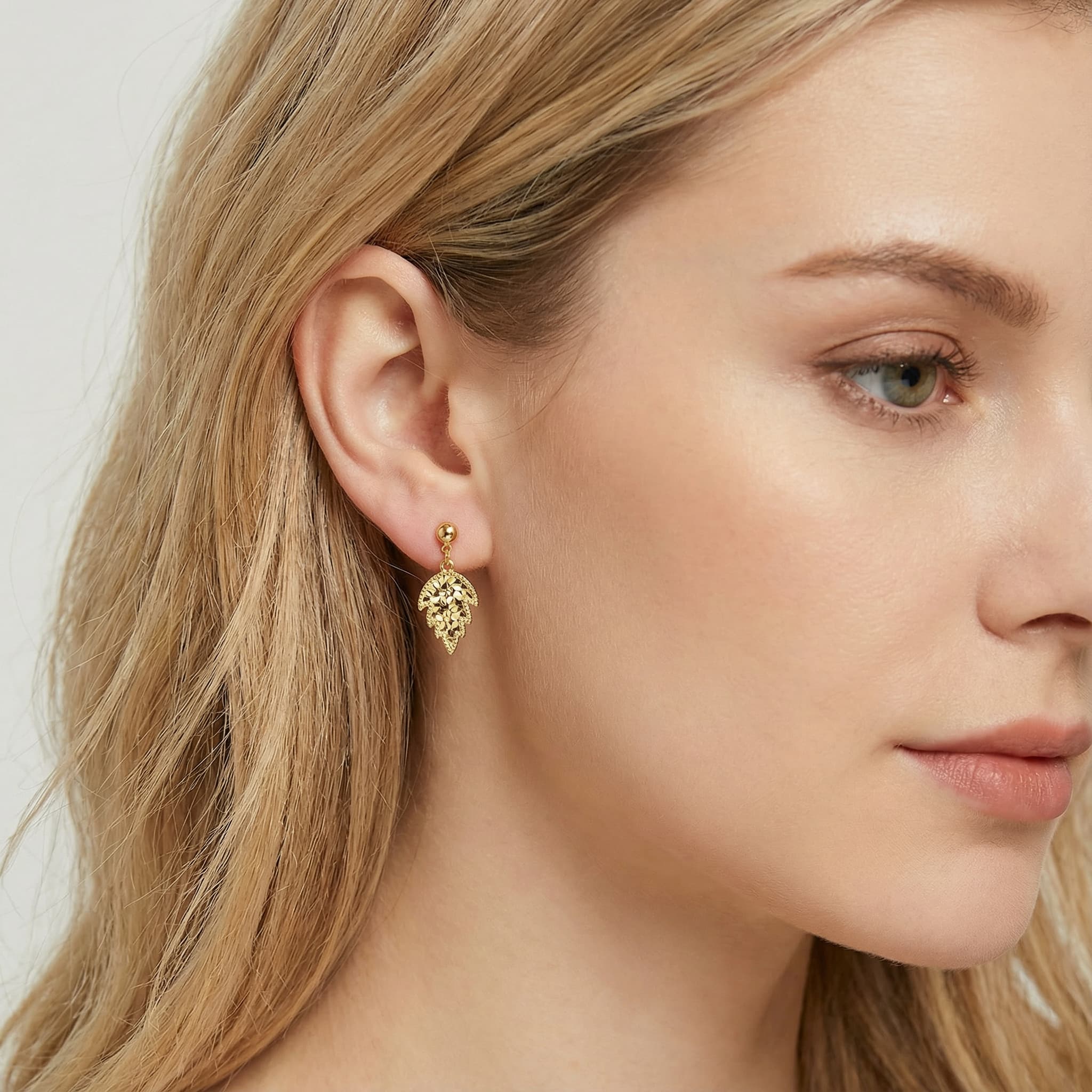 Model profile showing 24K gold vermeil maple leaf stud earrings.